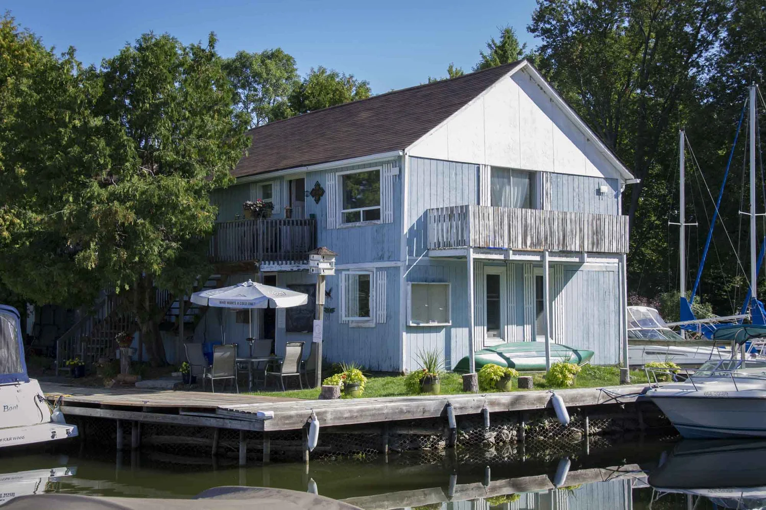 The blue clapboard Cooks Bay Marina house and docks on Lake Simcoe